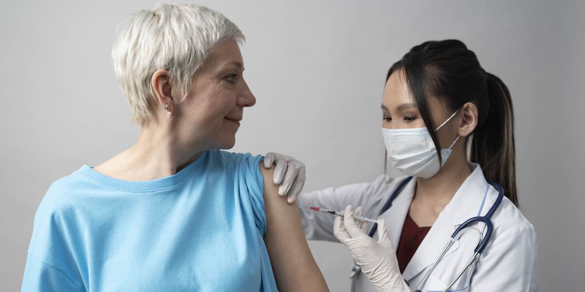 A nurse gives a woman her annual flu vaccine